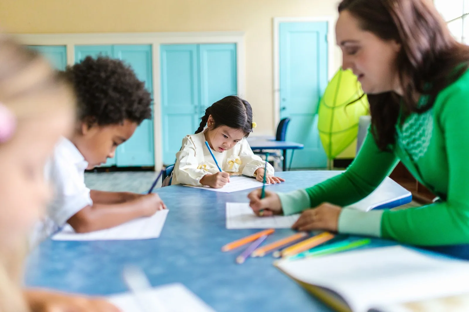 Children drawing with a teacher